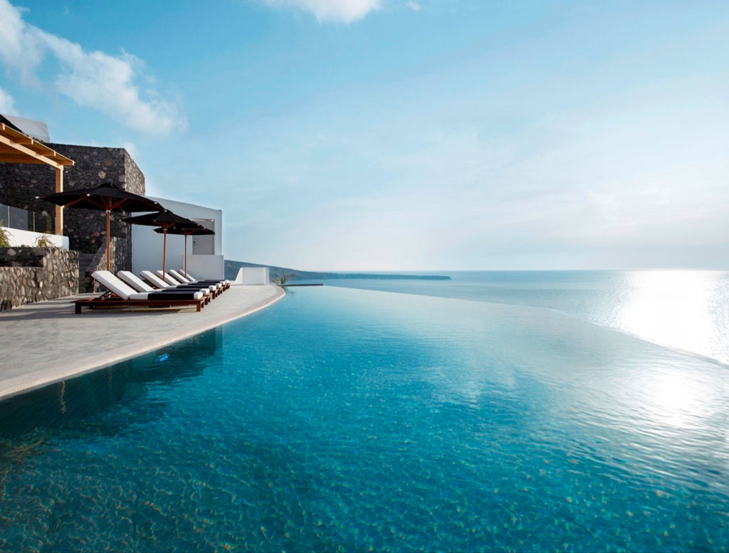 Elegant white-walled Greek villa with infinity pool overlooking Aegean Sea, featuring private terraces and minimalist Mediterranean design