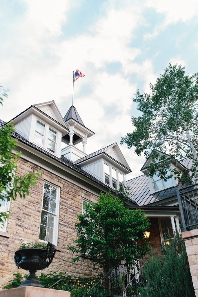 Luxurious boutique hotel interior with elegant white walls, vintage chandeliers, and sophisticated vintage furniture in a restored historic school building