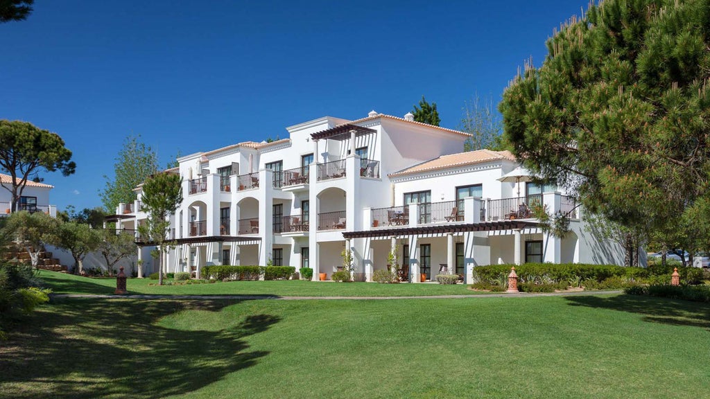 Modern beachfront hotel with grand terracotta architecture, private access to golden sand beach, and lush gardens overlooking the Atlantic Ocean.