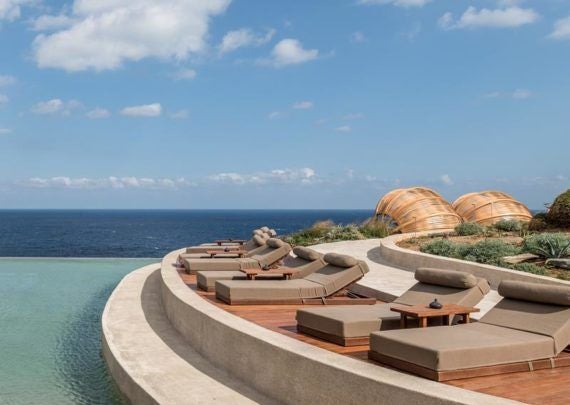 Modern Mediterranean hotel suite with private infinity pool overlooking the Aegean Sea, white-washed walls and elegant outdoor loungers