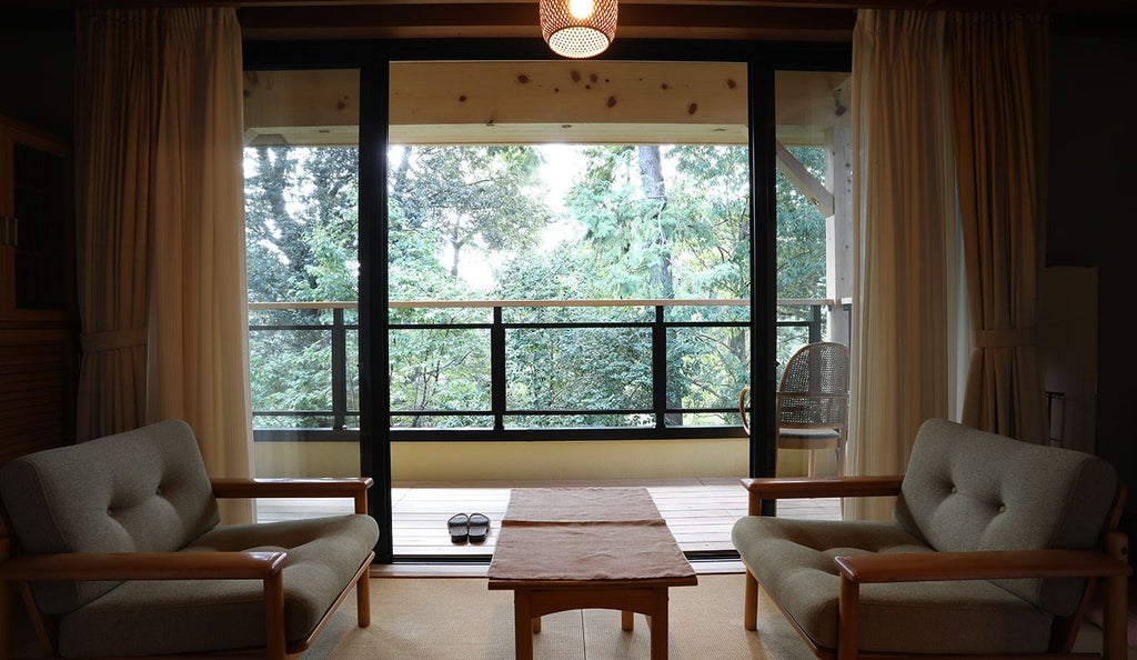 Minimalist Japanese-Western fusion room with tatami mats, low wooden table, sliding shoji screens, and elegant neutral color palette reflecting traditional ryokan design