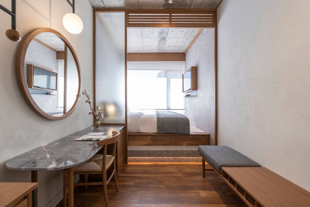 Minimalist small hotel room with clean lines, wooden floors, crisp white linens, and soft natural light illuminating elegant Greek design elements