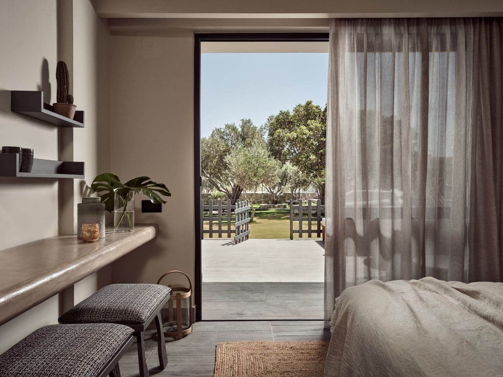 Luxurious king room with private terrace overlooking azure Cretan waters, contemporary design featuring green accents and elegant modern furnishings