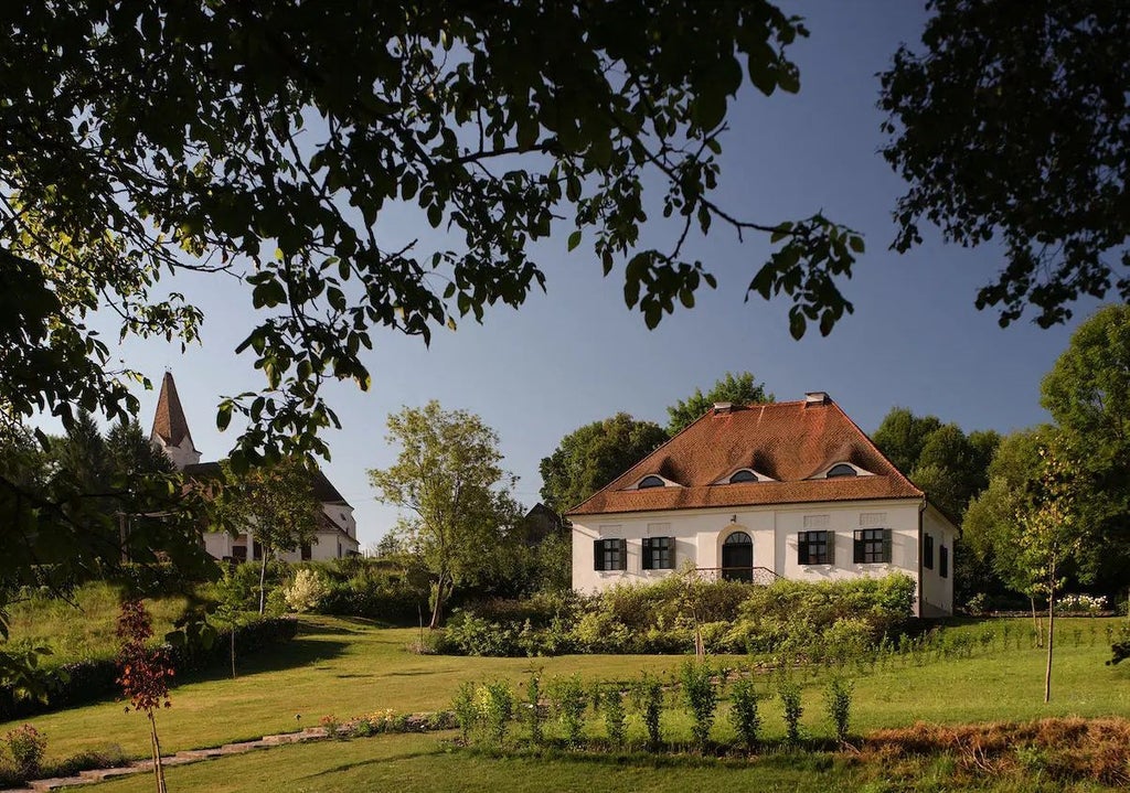 Luxurious restored manor house nestled in Romanian countryside, stone walls, wooden details, and manicured gardens showcasing Transylvanian architectural heritage