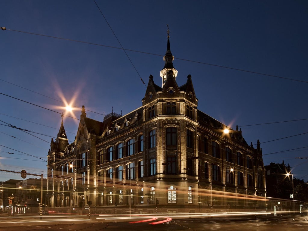 Luxurious contemporary hotel exterior with glass facade, blending modern architecture and historic building in scenic urban setting in Netherlands