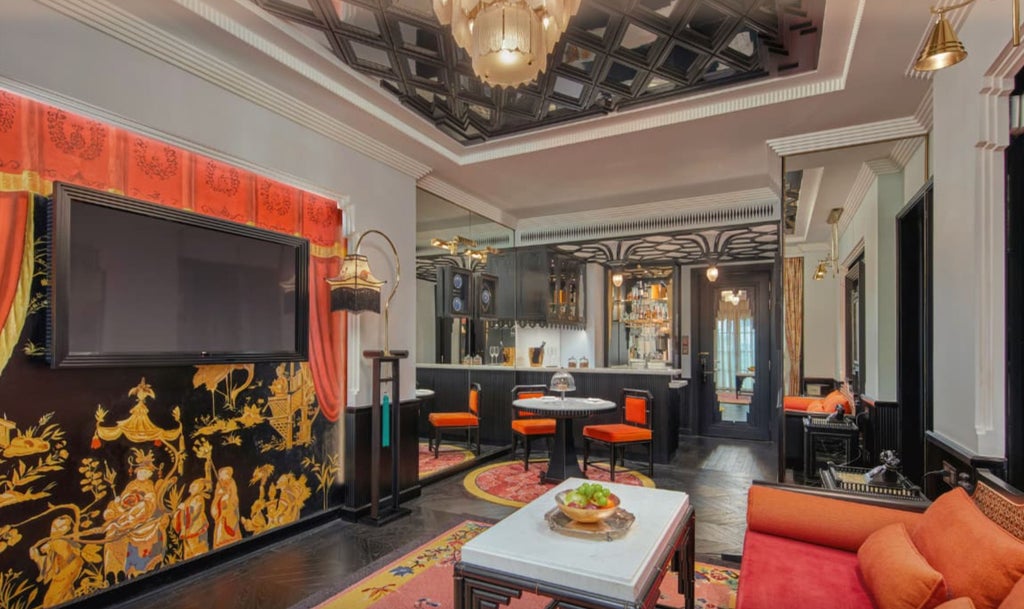 Opulent colonial-style suite with floor-to-ceiling windows, silk drapes, art deco furnishings, and private terrace overlooking Hanoi Opera House