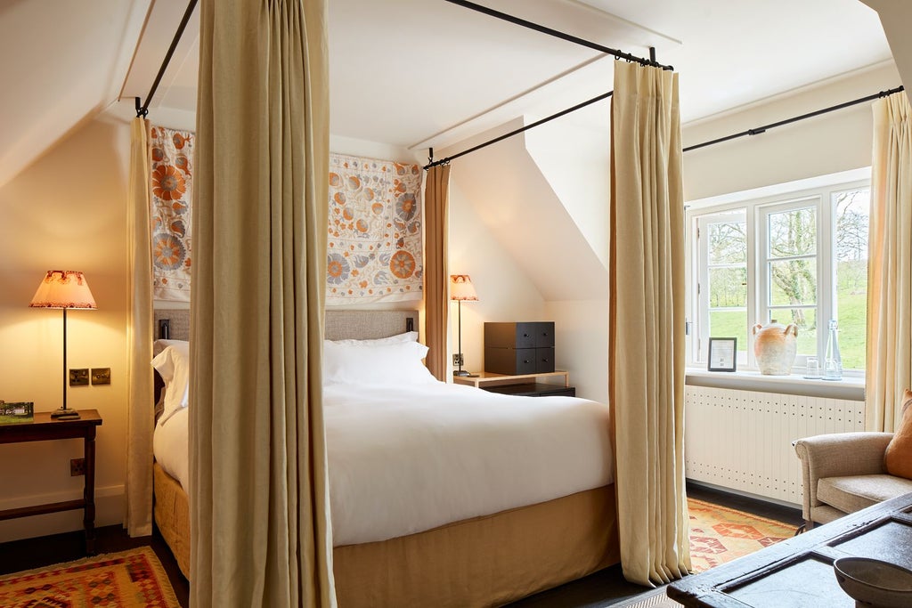 Elegant boutique hotel bedroom with soft neutral tones, plush bedding, and refined wooden furniture in a luxurious countryside setting at Grove of Narberth