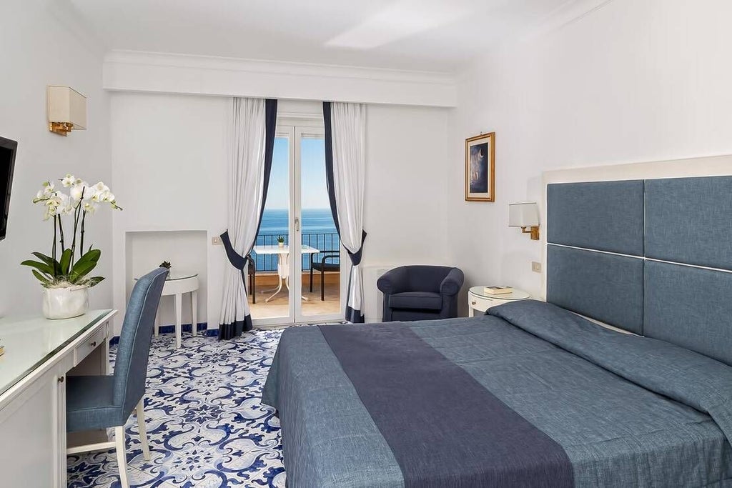 Elegantly designed Deluxe Room at Hotel Luna, featuring plush white bedding, modern Italian decor, panoramic window with soft natural light, and sleek marble bathroom