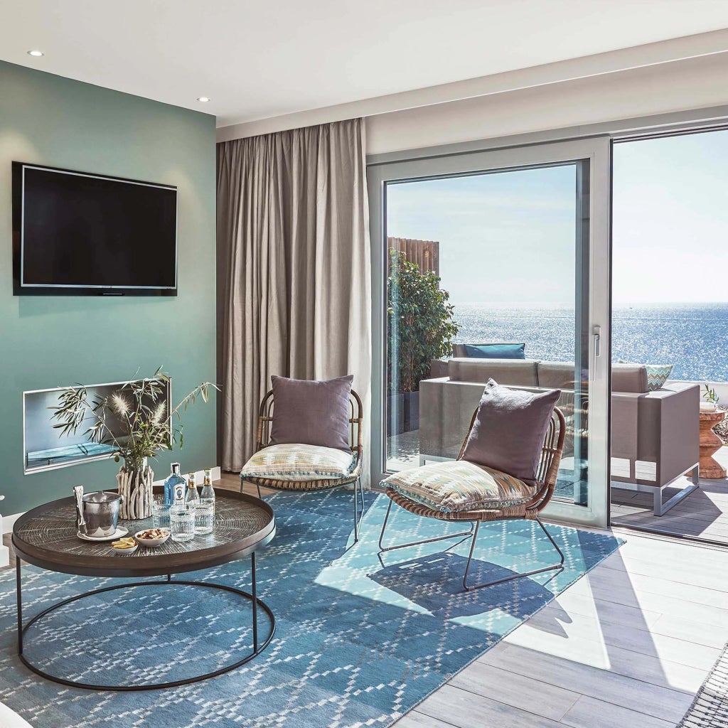 Luxurious two-level suite with panoramic Mediterranean sea view, infinity pool overlooking dramatic Ibiza coastline and sleek modern design