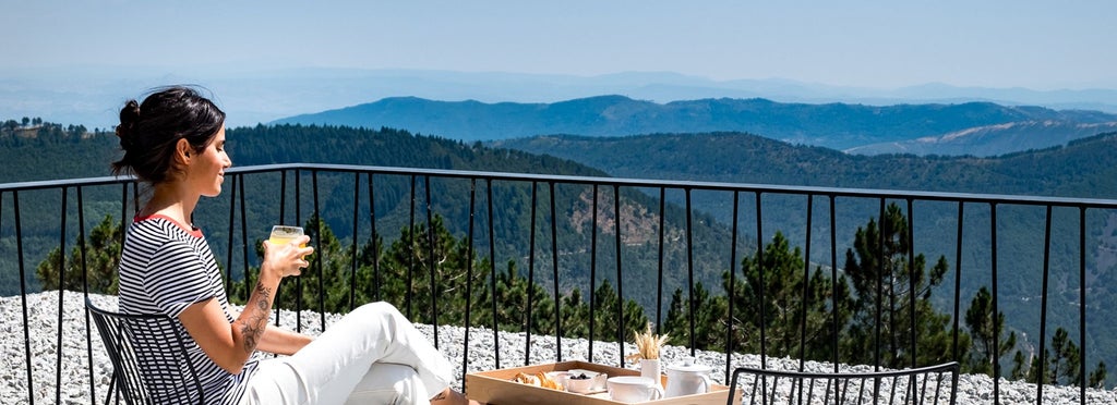 Luxurious minimalist hotel room with panoramic mountain views, featuring elegant Maria Keil-inspired design in neutral tones and modern Portuguese architectural style