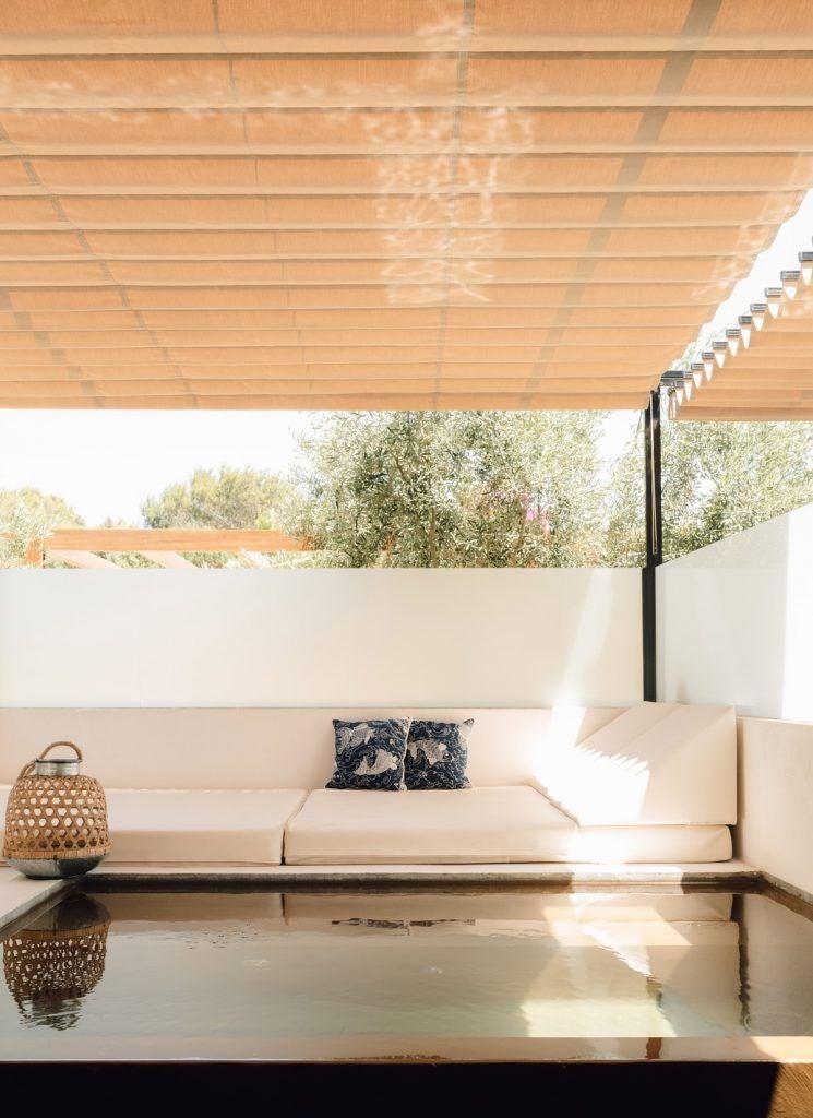 Luxurious poolside patio at Gecko Hotel & Beach Club, featuring sleek loungers, tropical greenery, and pristine turquoise pool with Spanish coastal ambiance