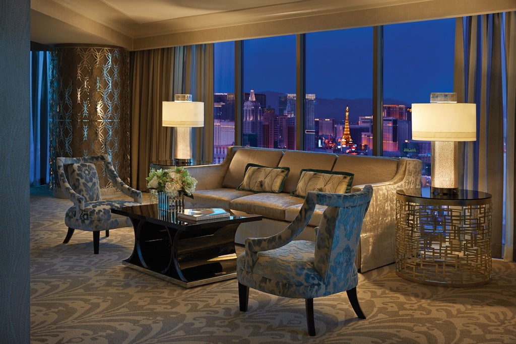 Luxurious Four Seasons hotel in Las Vegas with soaring glass facade, grand entrance featuring marble columns and elegant fountain at dusk