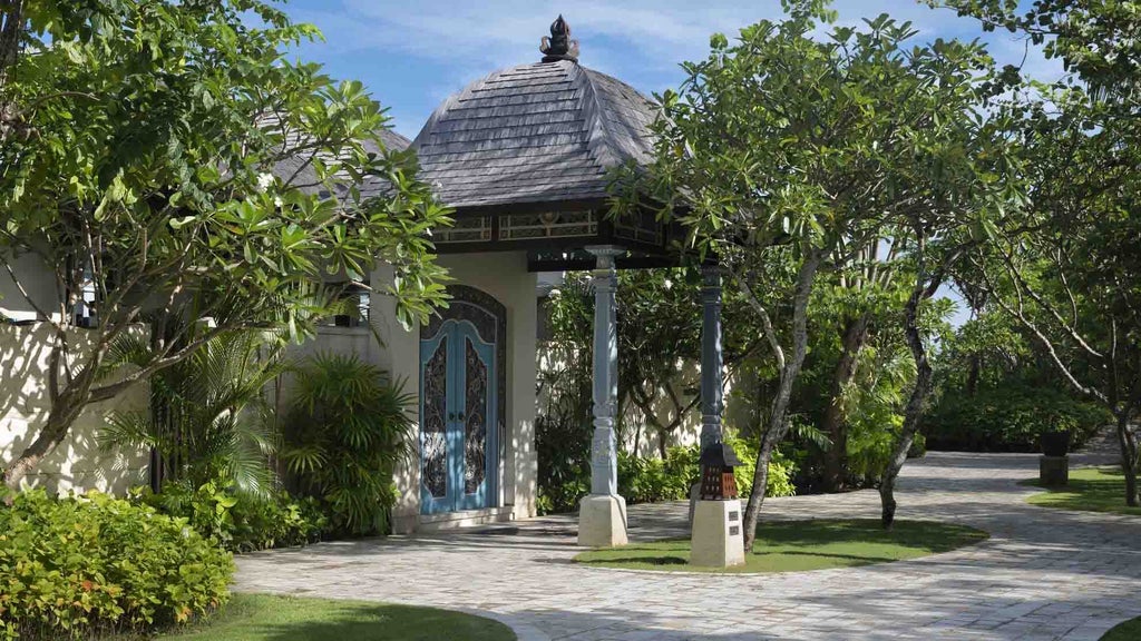 Luxurious Balinese villa bedroom with ocean views, private pool, canopy bed, white linens, and tropical garden landscaping