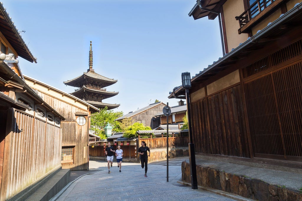 Modern luxury hotel with traditional Japanese architecture, featuring a tranquil stone garden, wooden walkways, and elegant landscaping