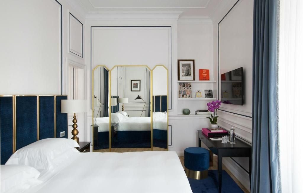 Elegant dama suite in Palazzo Dama hotel, featuring luxurious white marble bathroom, plush king bed, and panoramic Italian architectural details