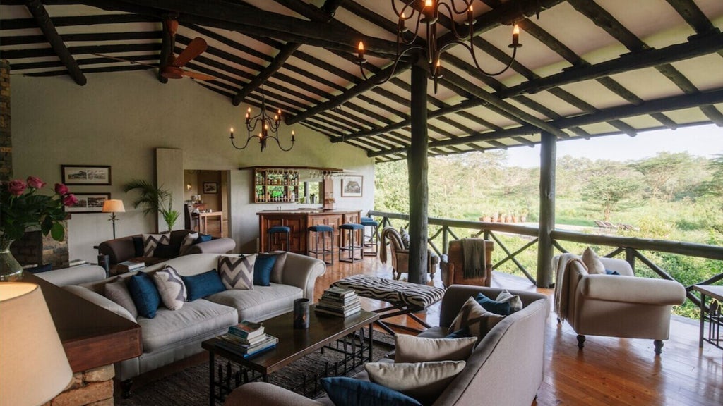 Luxury safari lodge perched on rocky hillside overlooking Nairobi National Park, featuring stone walls and thatched roof at sunset