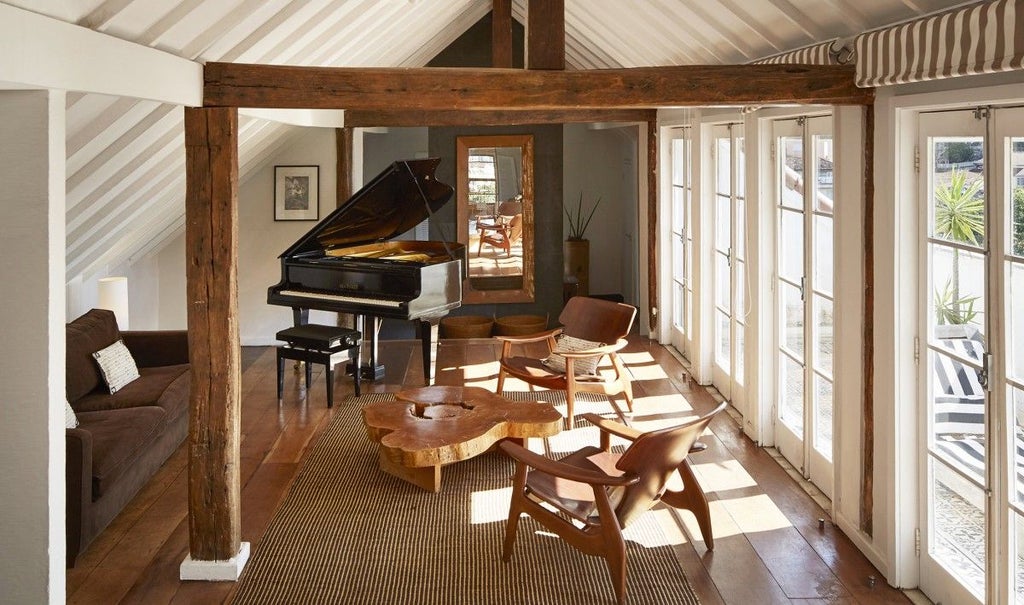 Elegant Royal Suite at Santa Teresa Hotel, featuring luxurious Brazilian decor with rich wood furnishings, crisp white linens, and expansive city view windows.