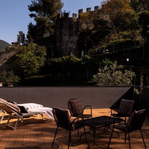 Elegant Italian deluxe hotel room with plush white bedding, ornate wooden furniture, and soft natural light streaming through traditional windows.