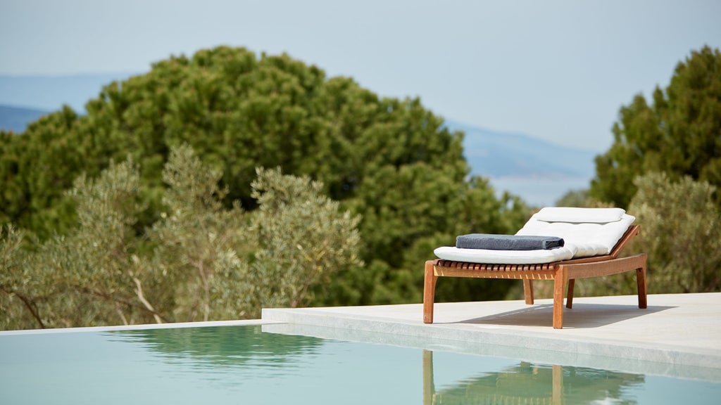 Luxurious junior suite with private pool overlooking azure Aegean waters, elegant white and blue decor, modern design, and scenic Greek island backdrop