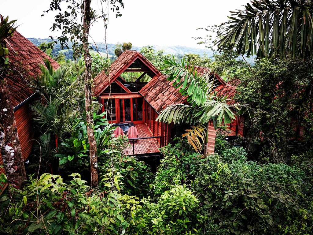 Luxurious mountain resort with modern glass-walled rooms overlooking lush rainforest and towering Arenal Volcano in Costa Rica