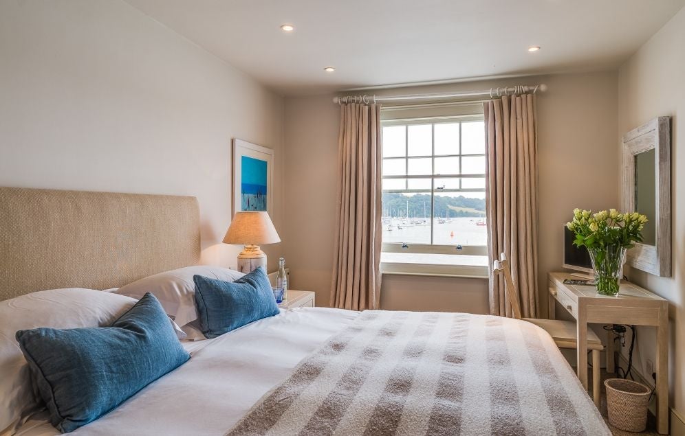 Luxurious seaview hotel room with panoramic coastal views, crisp white linens, nautical blue accents, and elegant maritime-inspired decor in St Mawes, United Kingdom.