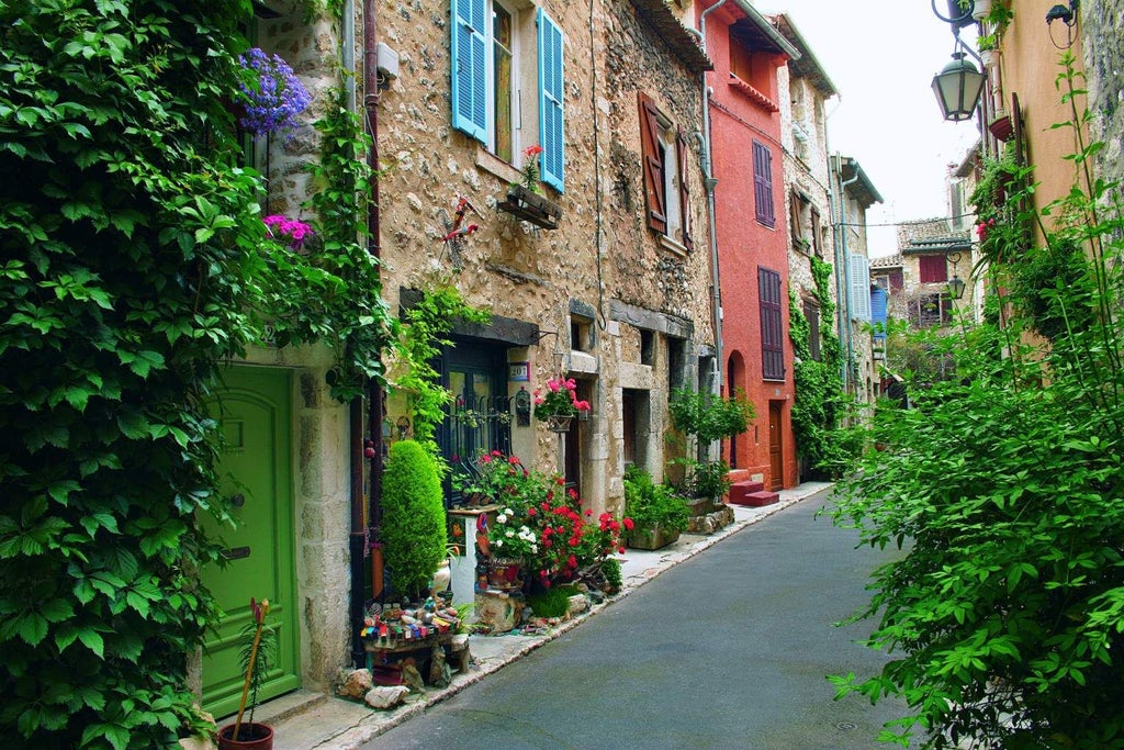 Elegant French countryside boutique hotel with stone facade, manicured gardens, and lavender beds framed by an ancient frêne tree at golden hour