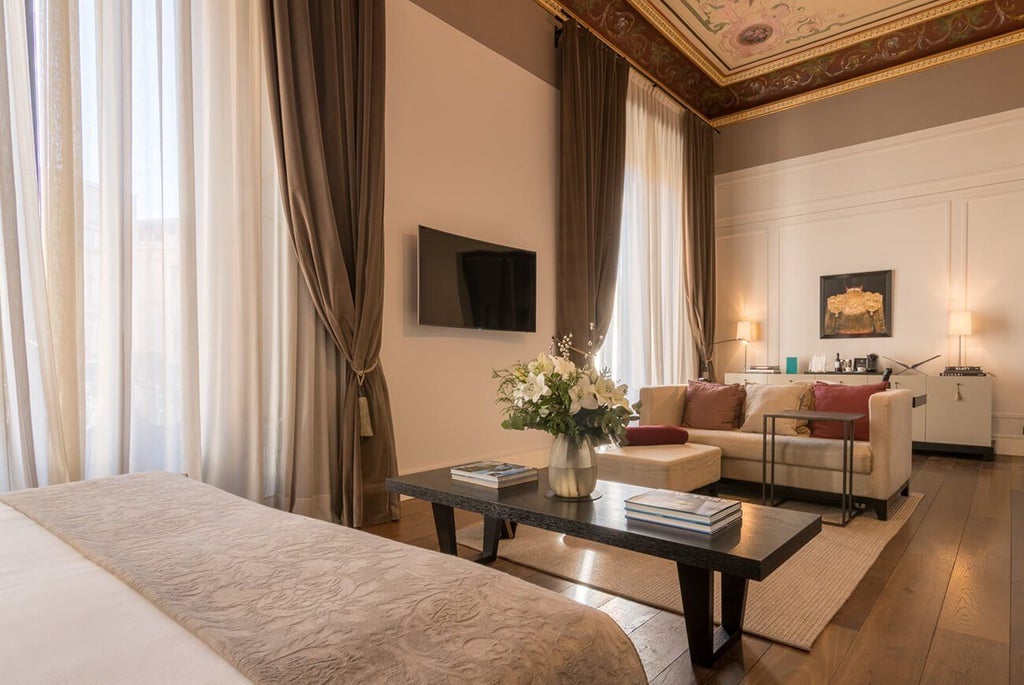 Elegant stone-walled suite with arched windows, luxurious king bed, and classic Spanish architectural details in Sant Francesc Hotel Singular, Mallorca