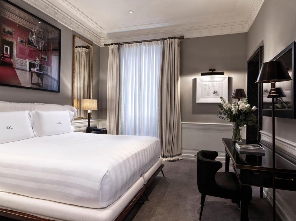 Elegant JK Deluxe Room at a luxurious Roma hotel, featuring sophisticated neutral tones, plush bedding, and refined contemporary Italian design elements