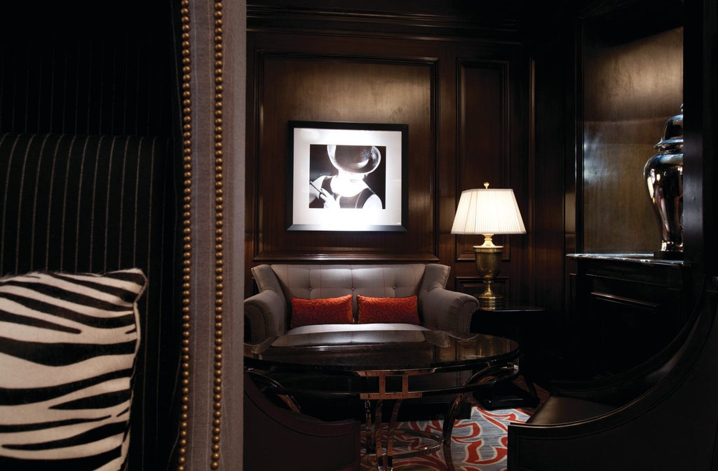 Elegant beige stone facade of Four Seasons Chicago with floor-to-ceiling windows, glass entrance canopy, and ornate exterior lighting