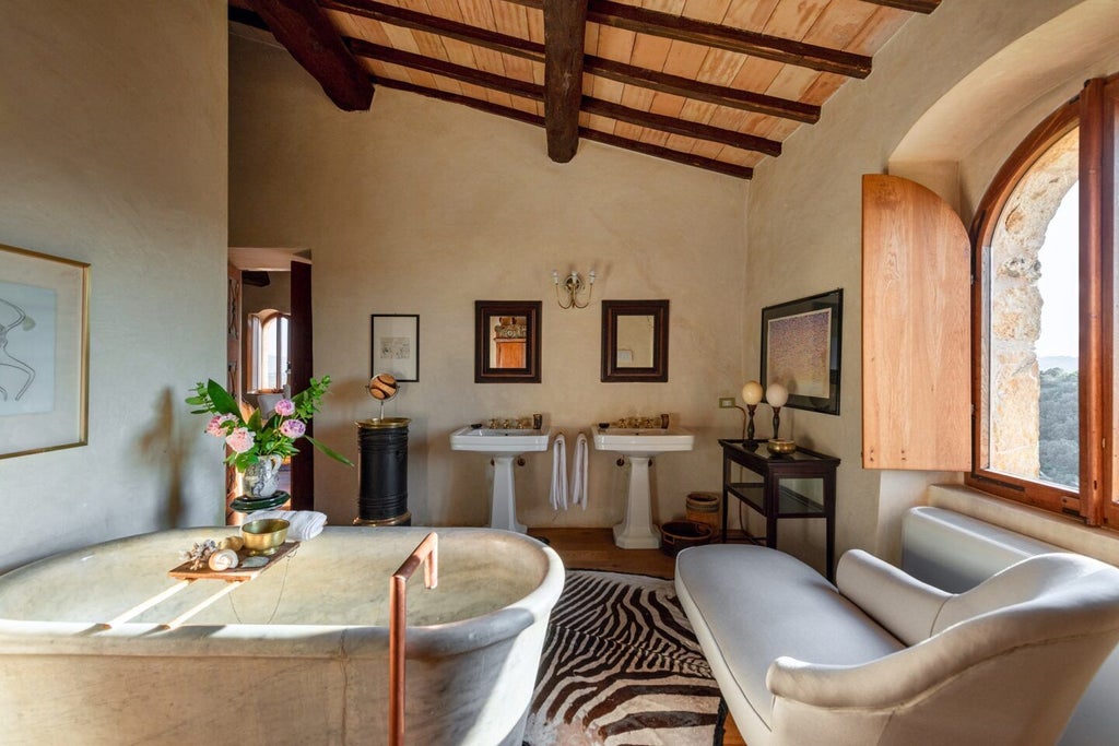 Elegant Tuscan stone suite with panoramic vineyard views, rustic wooden beams, and luxurious king bed in a restored medieval castle's tower room