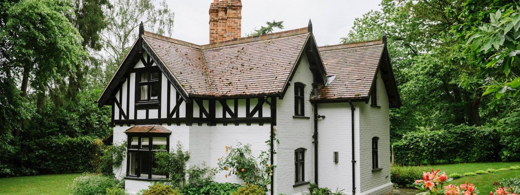 Elegant church-style lodge room at scenic [location] with plush white bedding, timber frame windows, and soft natural light streaming across refined furnishings