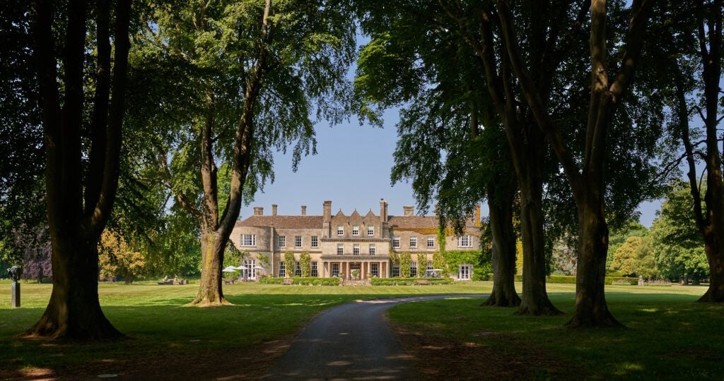 Elegant Regency-style manor hotel nestled in lush countryside, with manicured gardens, grand architecture, and a luxurious spa retreat in scenic United Kingdom landscape