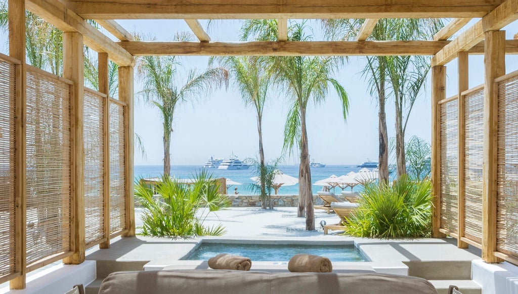 Luxurious white-themed Jacuzzi Sea View Suite at Branco Mykonos, overlooking azure Aegean waters with minimalist design and elegant furnishings