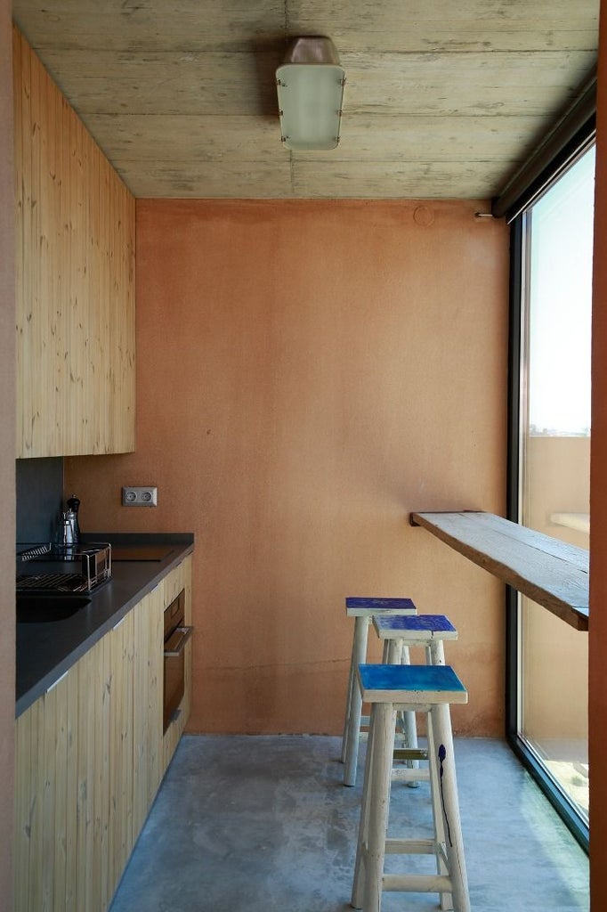 Luxurious wooden bungalow with ocean view at Noah Surf House, featuring minimalist design, warm lighting, and coastal Portugal landscape