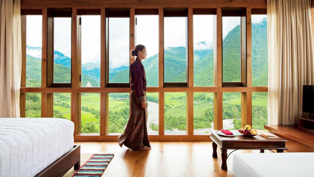 Luxurious valley-view hotel room at COMO Uma Punakha, featuring elegant minimalist design with natural wood accents and panoramic Bhutanese landscape views