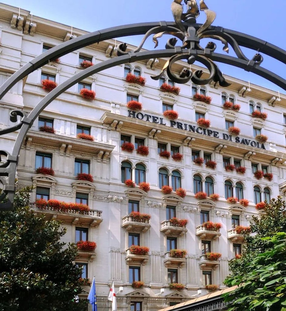 Opulent luxury hotel exterior with ornate Renaissance-style architecture, grand entrance flanked by marble columns and manicured gardens