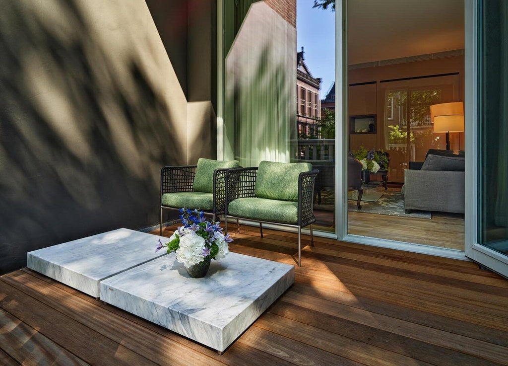 Luxurious garden-view suite at Conservatorium Hotel, Amsterdam, featuring elegant modern design with natural light, plush furnishings, and sophisticated interior styling