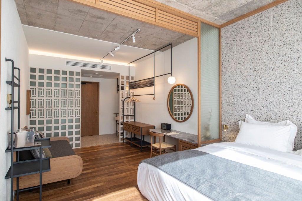 Minimalist medium room with warm wooden accents, crisp white linens, and urban Athens view at stylish Ergon House boutique hotel, showcasing modern Greek hospitality