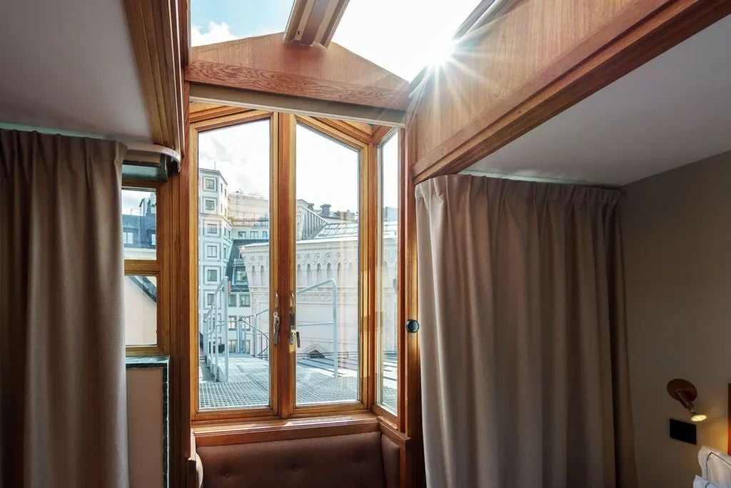 Elegant hotel room at Berns Hotel with plush bed, soft neutral tones, designer headboard, luxe textiles, and warm ambient lighting in Stockholm