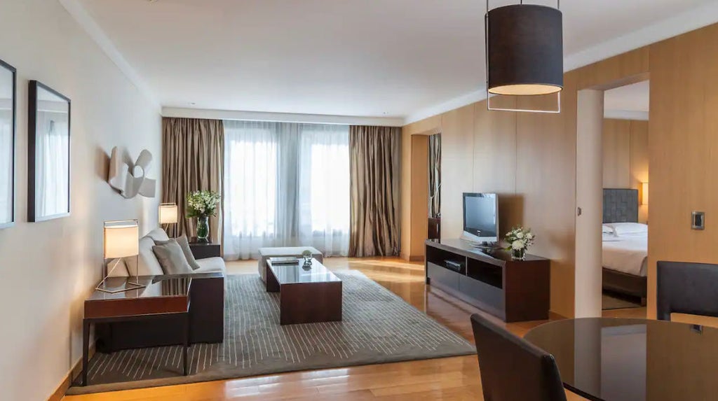 Elegant hotel suite with white marble bathroom, freestanding soaking tub, crystal chandelier and large windows overlooking Buenos Aires