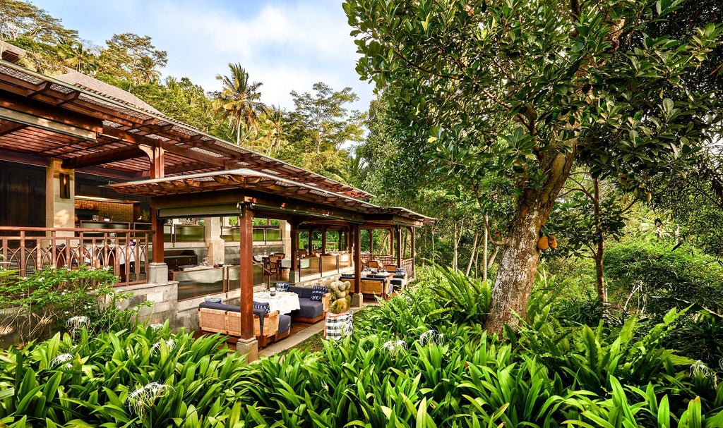 Elegant wooden villa nestled in lush Balinese jungle with private infinity pool overlooking green rice terraces at sunset