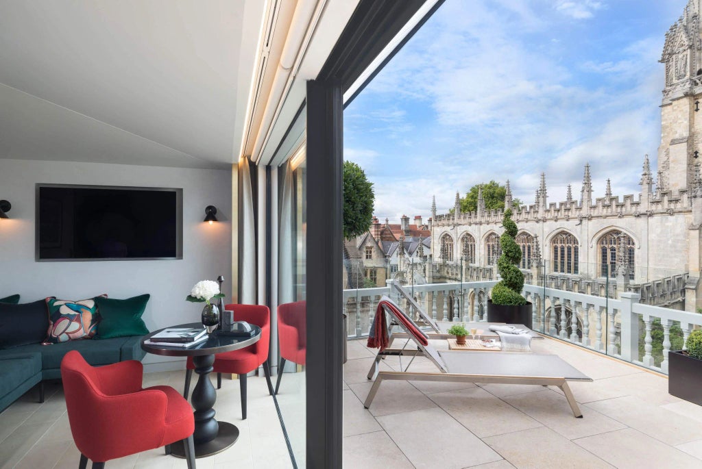 Elegant hotel room with large windows overlooking classic UK architecture, featuring sophisticated decor and timeless wooden furnishings in a historic bank building