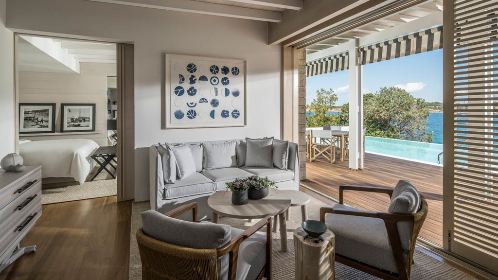 Elegant bungalow suite overlooking Aegean Sea with private infinity pool, modern furnishings and floor-to-ceiling windows framing coastal views