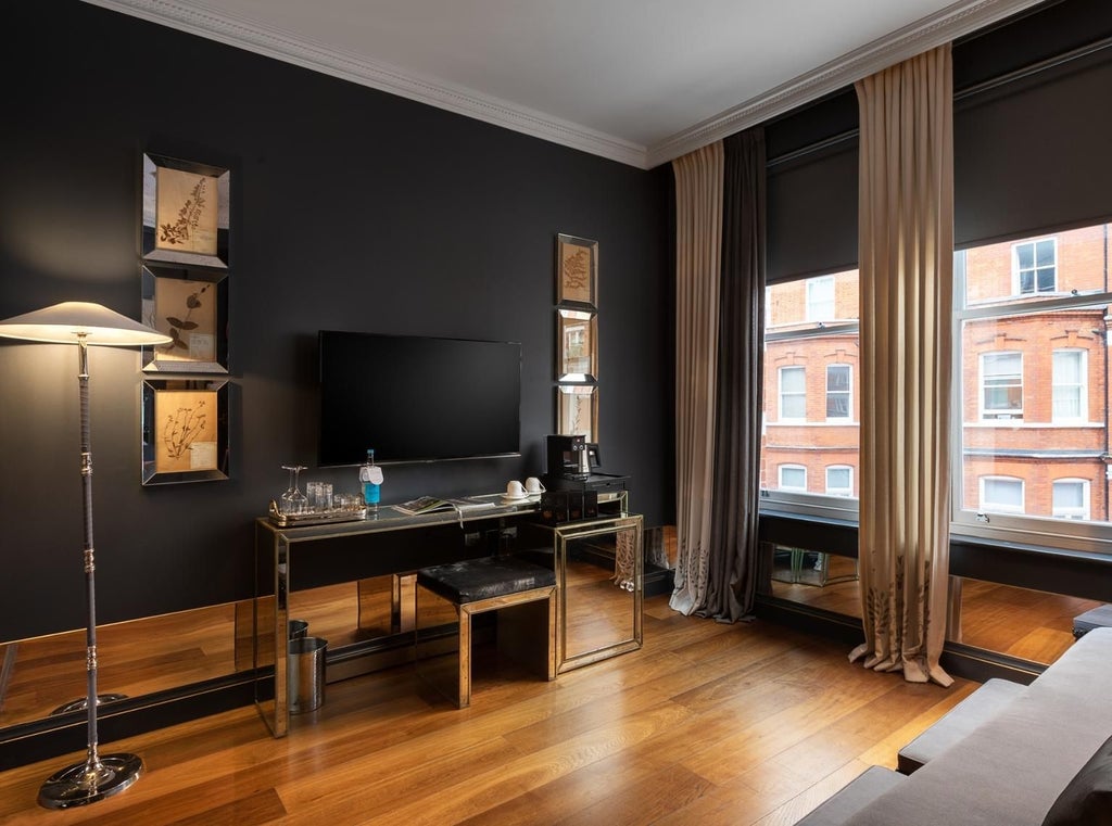 Elegant executive suite with plush king bed, contemporary dark wood furnishings, floor-to-ceiling windows overlooking urban landscape, refined neutral color palette