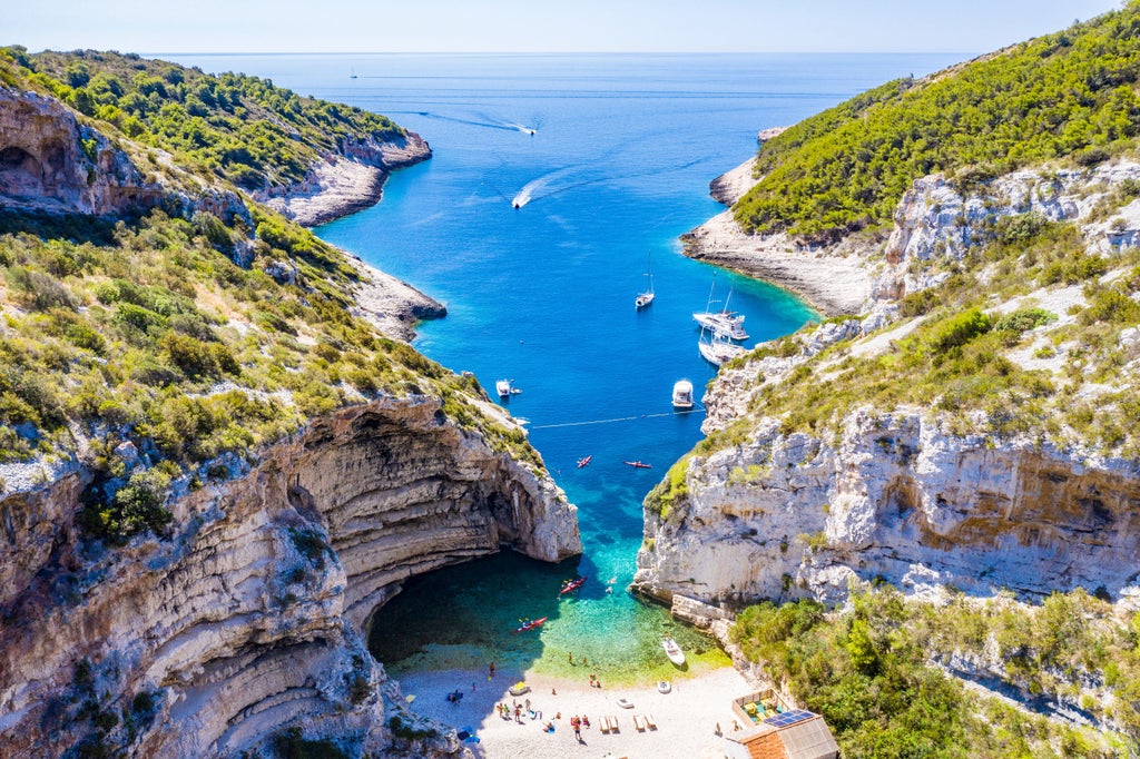 Luxury speedboat cruising crystal-clear Adriatic waters between Split and Hvar, with coastal mountains and blue skies in background