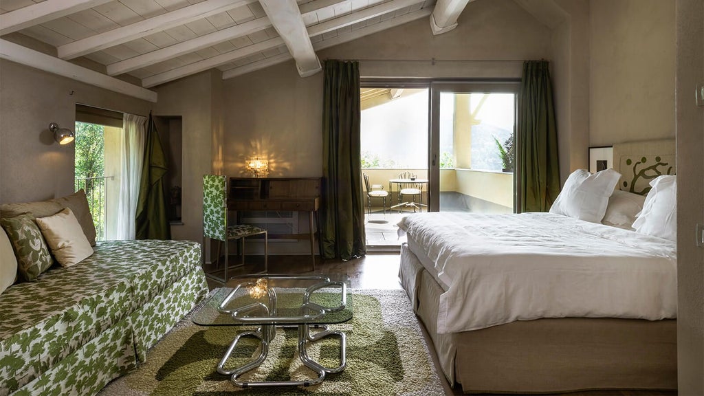 Elegant, sun-drenched bedroom in Tuscan boutique hotel with minimalist white decor, natural wood accents, and panoramic countryside views through large windows.