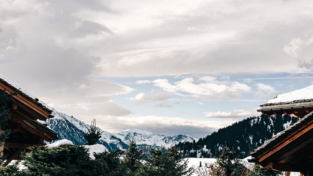 Luxurious wooden alpine chalet nestled in Swiss mountains, featuring expansive windows, modern minimalist design, and snow-capped peaks in background