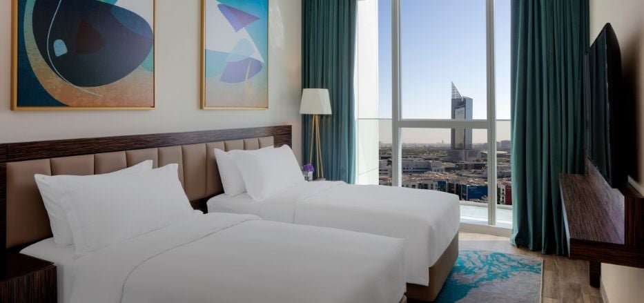 Spacious superior one-bedroom apartment with modern design, plush furnishings, and floor-to-ceiling windows overlooking Dubai's vibrant cityscape at Avani+ Palm View Hotel