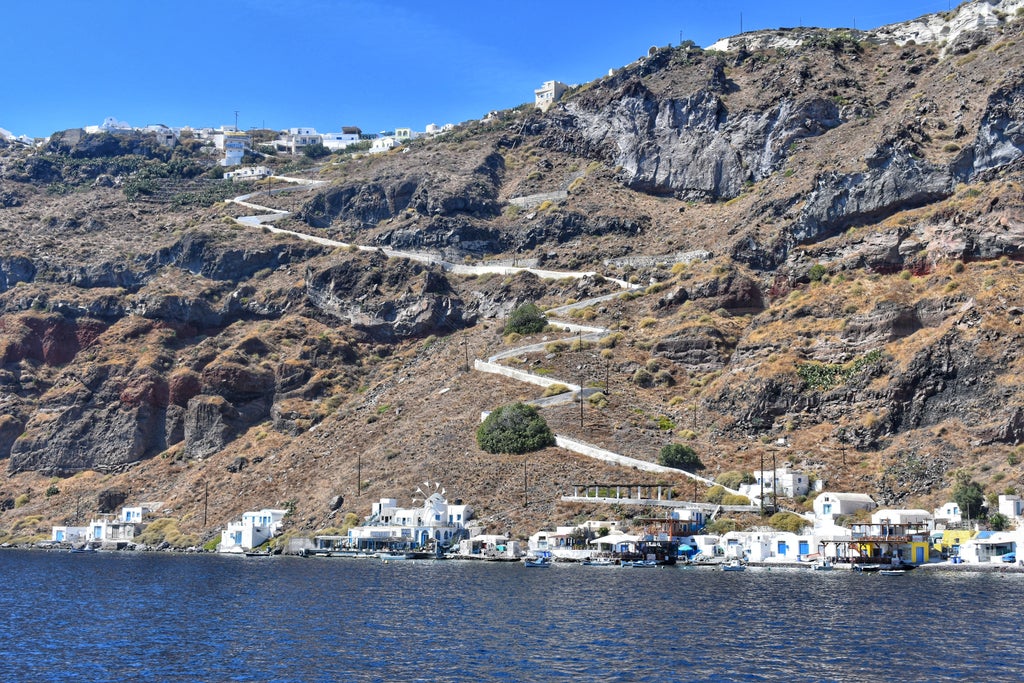 Scenic hiking trail on Thirasia island, Greece, revealing stunning Aegean Sea views with rugged volcanic landscape and lush Mediterranean vegetation