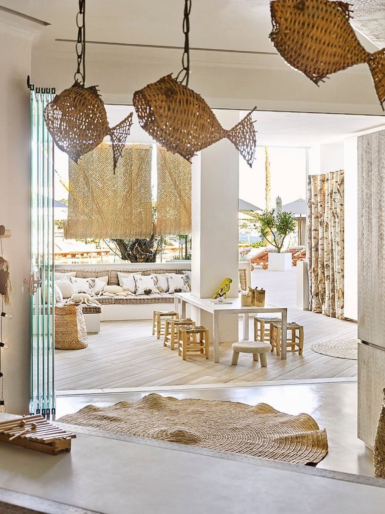 Luxurious beachfront suite at scenset hotel with turquoise waters, white minimalist decor, and elegant Mediterranean-inspired design overlooking pristine coastline